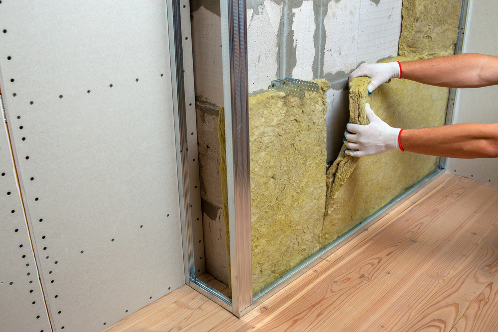 Worker insulating a room wall with mineral rock wool thermal ins Plaquiste Limoges